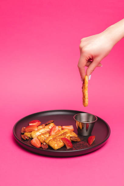 istock Delicious appetizer of deep-fried cheese with jam under strawberries on a pink background. 1938481801