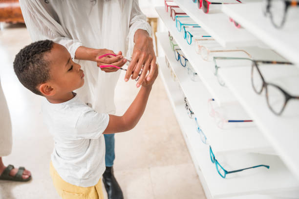 istock Expert Optician Assists Mixed Race Boy in Eyeglass Selection 1938535324