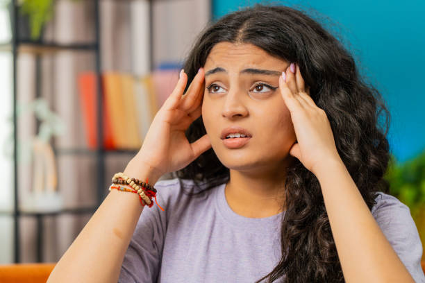 istock Sick ill Indian woman rubbing temples to cure headache problem, suffering from migraine, stress 1938540072