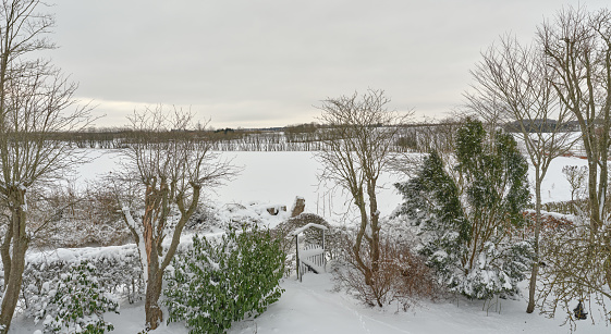 Garden and countryside covered with snow and frost. Denmark in winter.