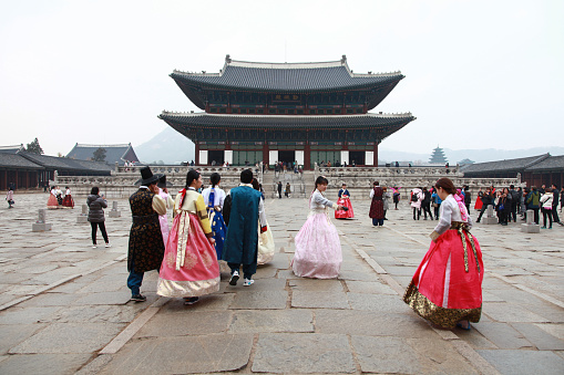 Seoul, South Korea - November 27, 2016. The Gyeongbokgung Palace in Seoul. Visitors dressed in traditional Korean Hanbok costumes.