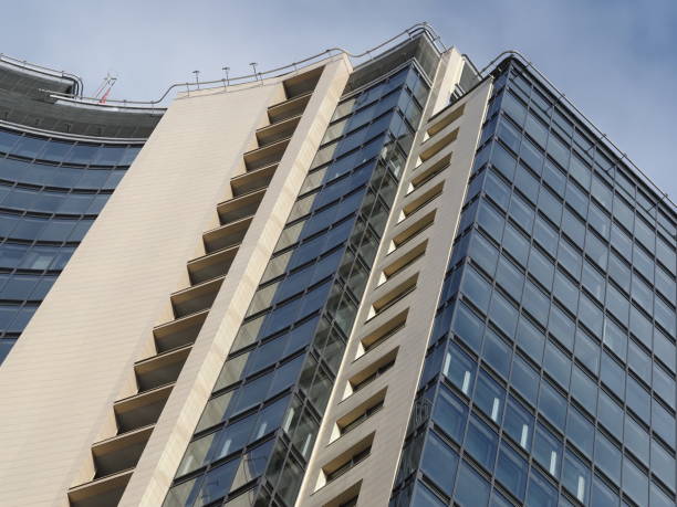 istock Facade of a modern skyscraper against a blue sky with clouds 1938598060