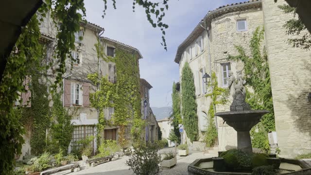 historic small market square in an old village in France with many old stone houses in good weather