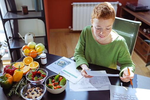 A female nutritionist is making a nutrition plan for her clients. Concept of eating a wide variety of foods in the right proportions.