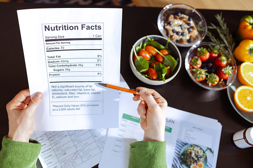 A female nutritionist is making a nutrition plan and reading nutrition facts