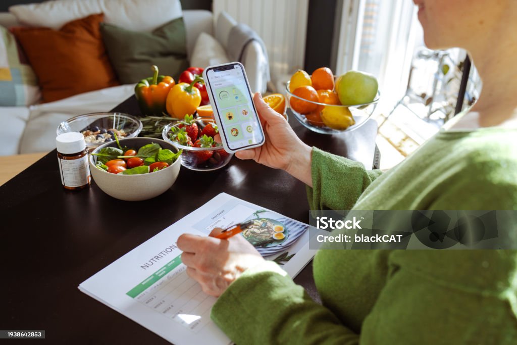 Checking Nutrition A Woman Is Making A Weekly Nutrition Plan And Using Mobile App Stock ...