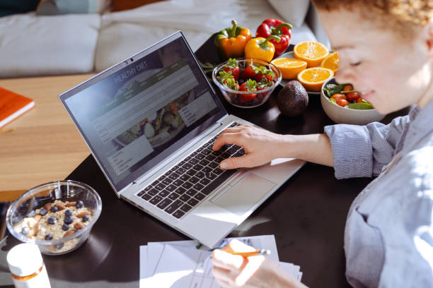 istock Female nutritionist makes a diet plan for a client and using laptop 1938650718
