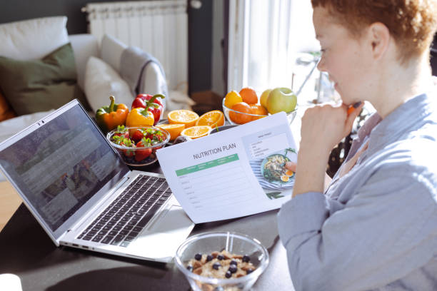 istock Female nutritionist makes a diet plan for a client and using laptop 1938652322