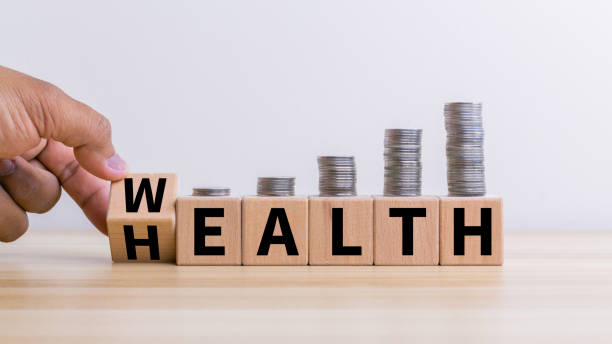 istock Hand flip wooden cube with word wealth to health with coins stack step up growing growth value. Investment in life insurance and healthcare concept 1938667914