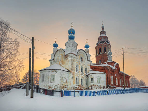 Resurrection Cathedral cherdyn. Ancient architecture is surrounded by tall white drifts and orange sunset skies. Historical center of the ancient city of Cherdyn, Russia in the middle of winter
