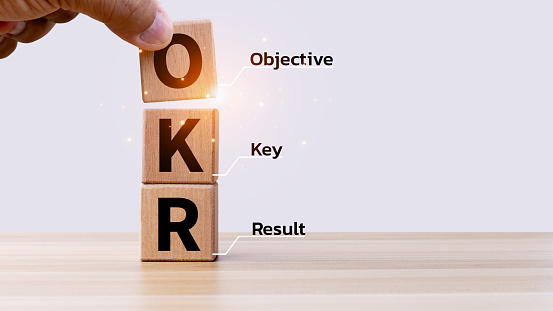 OKR text on wooden cube blocks on white background. Business target and drive business and performance. Focus on goal. Achieve business growth by flexible management.