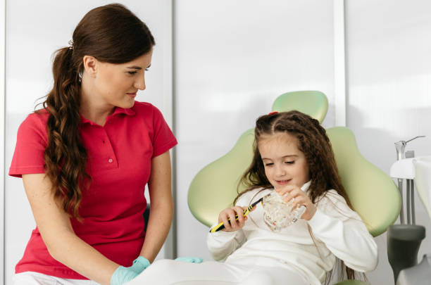 istock Dentist teaching girl how to brush teeth 1938690058