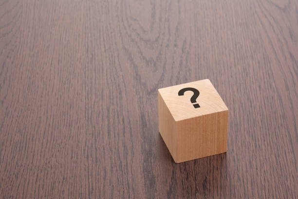 istock one wooden block with question mark over a brown background with copy space 1938694374