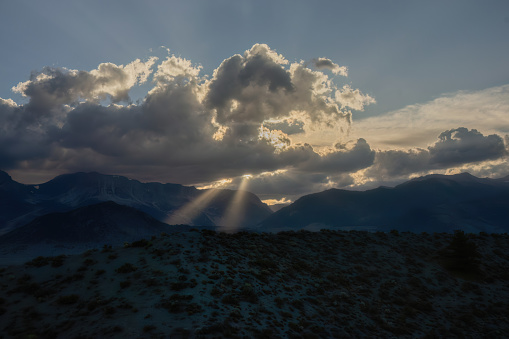 A mountain view with the sun setting in the distance at Mono Lake with insane light rays.