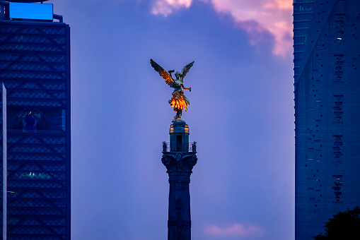The Angel of Independence statue located in downtown of Reforma avenue of Mexico city against cloudy sunset sky
