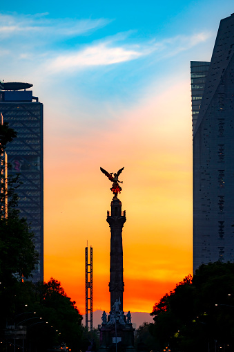 Famous statue The Angel of Independence on Reform avenue in Mexico city against colorful sky in sunset