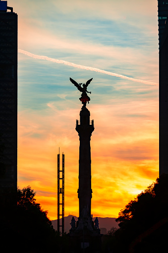 Statue The Angel of Independence on Reform avenue in Mexico city against colorful sky in sunset