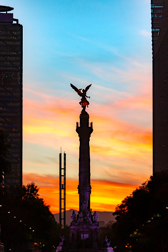 Statue The Angel of Independence on Reform avenue in Mexico city against colorful sky in sunset