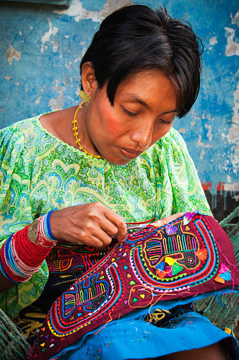 Kuna Yala, Panama - August 2, 2006: A Kuna Indian woman embroiders a colorful design on a traditional mola in Central America
