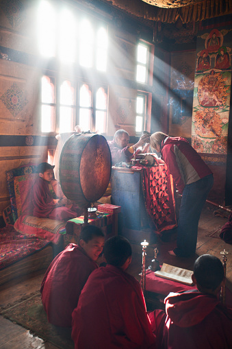 Lama bestows a private blessing on a tourist for a safe journey home; Ura temple, Ura village, Bumthang valley, Bhutan