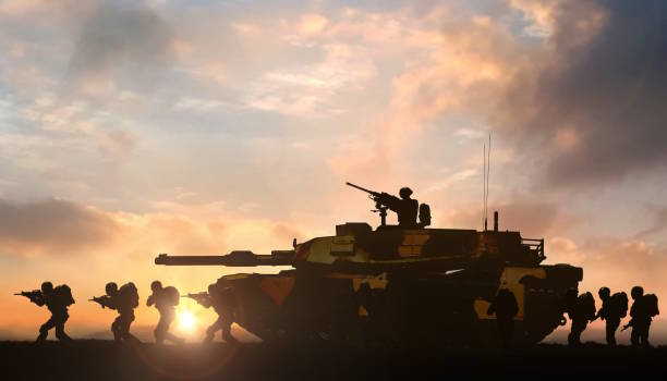 Military operation with tank support on battlefield at sunset