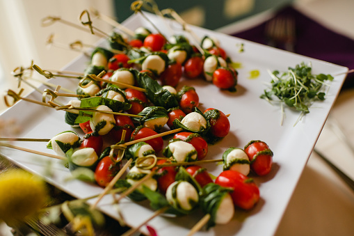 Caprese skewers with tomatoes, mozzarella and basil on serving plate in Chicago, Illinois, United States