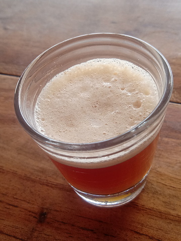 Plastic cup of light beer standing on the table, Disposable glass