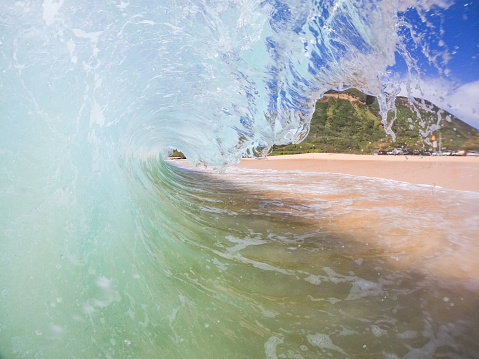 A low wide angle view inside a barrel on a sunny day at Keiki's surf break, North Shore, Oahu.