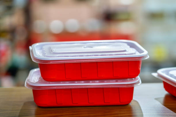 Little tomatoes in PET Plastic containers on dark blue and white Scottish background. Red and blue contrast playing.
