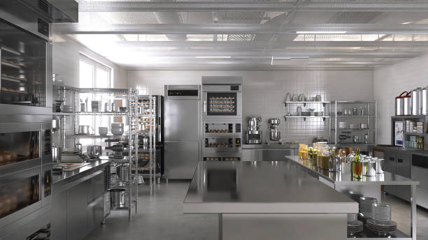 istock Empty clean stainless steel island table in commercial, professional bakery kitchen with convection, deck oven, freezer, refrigerator, shelf, cabinet, equipment in background 1938952595