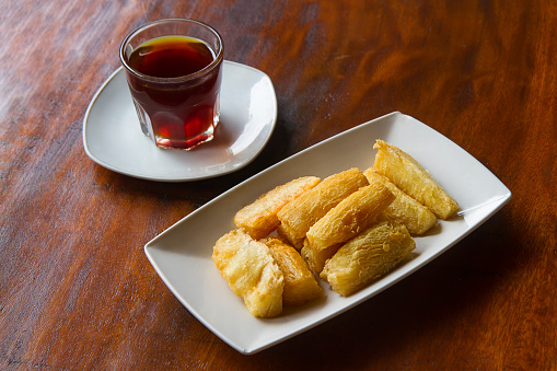 Deep fried cassava root with a cup of coffee. Brazilian Mandioca Frita (deep fried cassava/ manioc/yuca). Feijoada side dish
