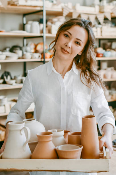 istock A female potter holds a box with raw clay products 1938972741