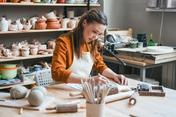 istock Middle-aged woman moulding a plate in a pottery studio 1938972760