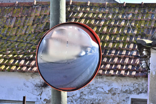 Round convex traffic mirror on the alley for better visibility. Convex mirrors provide a wider field of view on roads, driveways and in alleys, Indonesia, 20 June 2024.