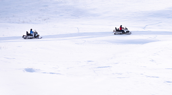 Two people driving a snowmobile in Colorado, USA