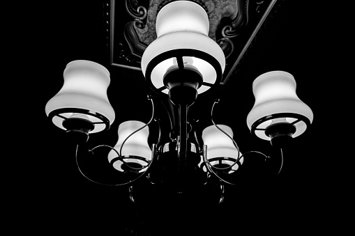 chandelier hanging from the ceiling, hanging lamps illuminate the darkness.
