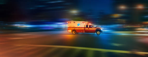 Ambulanza che accelera di notte su una chiamata urgente a Manhattan, New York - azione di panoramica del motion blur - foto stock