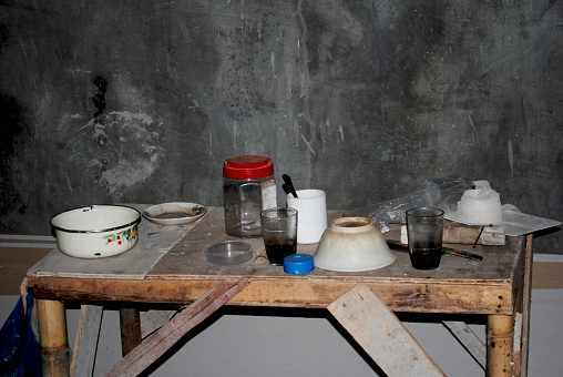 Scattered eating and drinking utensils inside an unfinished house.
