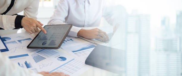 Businesspeople evaluate project efficiency and financial figures with business team for marketing research and business strategy plan.