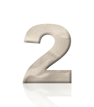 Close-up of three-dimensional sand number 2 on white background.