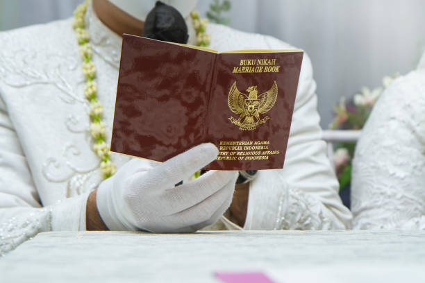 istock Bride and groom holding Indonesian marriage certificate 1939094562