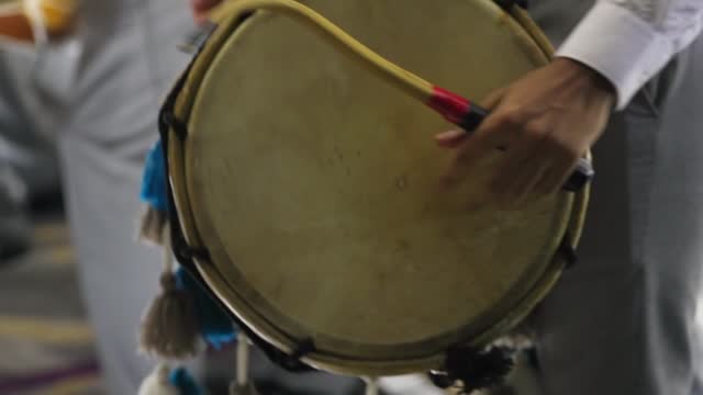 Dhol drummer rhythmic hitting the dhol in slow motion. Close up.