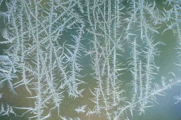 frost crystal on window glass in winter season - frosted glass glass textured crystal stock-fotos und bilder