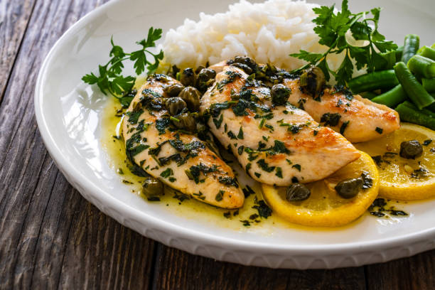 istock Chicken piccata with white rice and capers in sauce on wooden table 1939127849