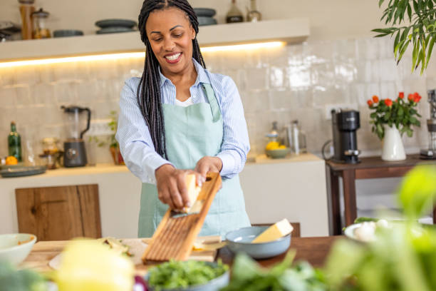 istock Woman rubs cheese on grater in the kitchen 1939146830