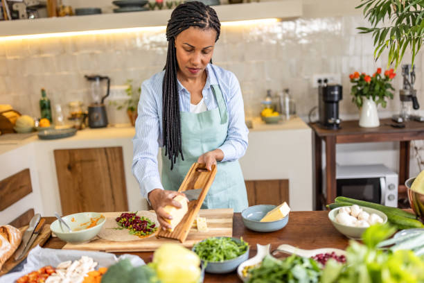 istock Woman rubs cheese on grater in the kitchen 1939146880