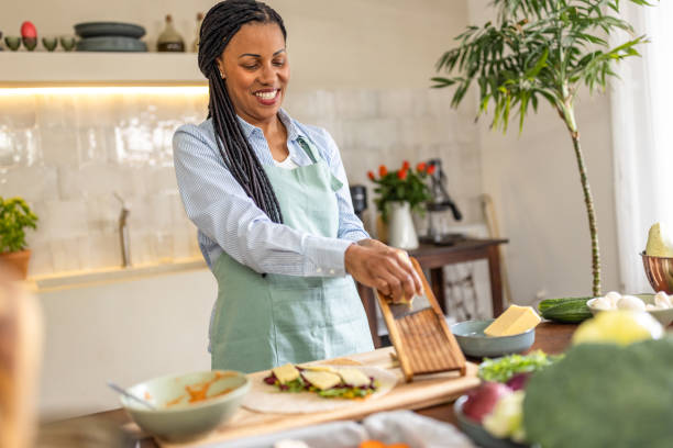 istock Woman rubs cheese on grater in the kitchen 1939160497