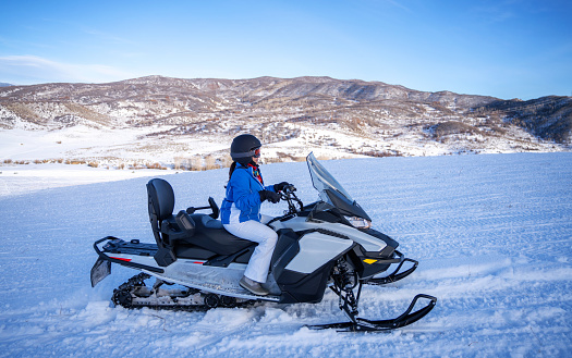 Hispanic woman driving a snowmobile in Colorado, USA