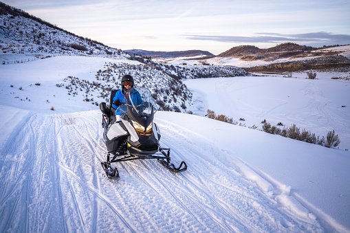 Latin woman driving a snowmobile in Colorado, USA