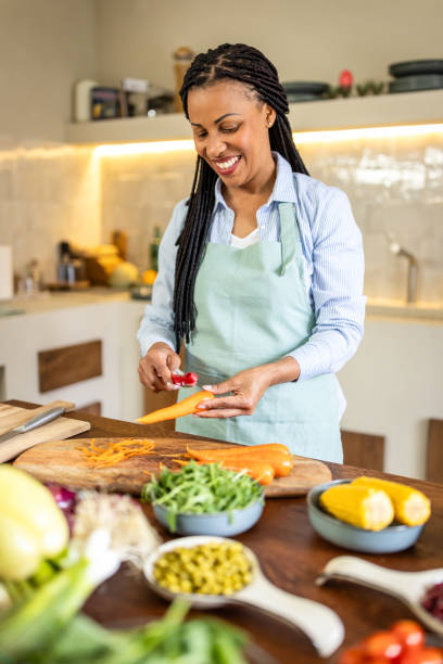 istock Woman peeling carrots in the kitchen 1939178790